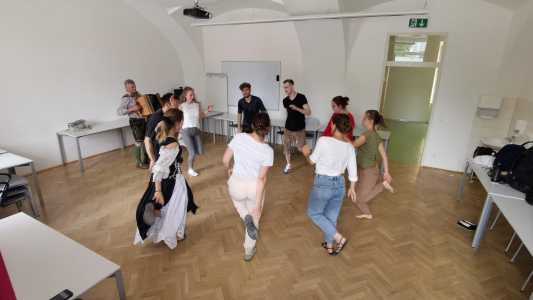 Studierende und Anleitender beim Schuhplattln/Volkstanzen