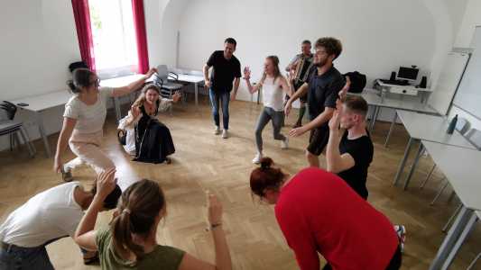 Studierende und Anleitender beim Schuhplattln/Volkstanzen