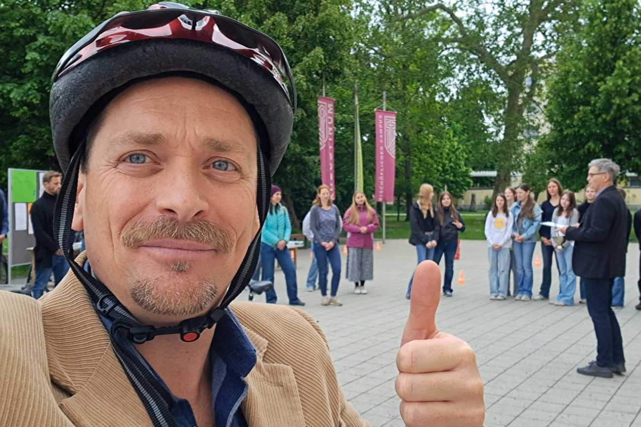 Lehrender mit erhobenem Finger bei der Fahrradsegnung