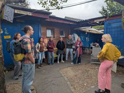 Vortragende mit Studierenden im Containerdorf